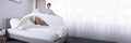 Housekeeper Arranging Bedsheet On Bed Royalty Free Stock Photo