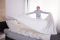 Housekeeper Arranging Bedsheet On Bed Royalty Free Stock Photo