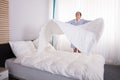 Housekeeper Arranging Bedsheet On Bed Royalty Free Stock Photo