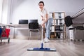 Female Janitor Cleaning Floor In Office