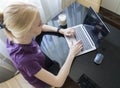 Smiling young female lying on the floor in the living room student studying at home working with her laptop computer Royalty Free Stock Photo