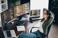 Young female programmer enjoying break while working on multiple screens in a modern workspace with coding displayed. Royalty Free Stock Photo