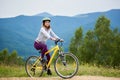 Young happy woman riding bicycle in the mountains at summer day Royalty Free Stock Photo