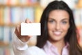 Smiling young female showing a business card