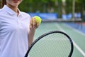 Smiling young female tennis player holding ball racket sitting on the bench at tennis court Royalty Free Stock Photo