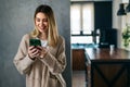 Smiling young female using mobile phone app playing game, shopping online, ordering delivery Royalty Free Stock Photo