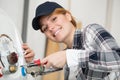 smiling young female worker fixing boiler Royalty Free Stock Photo