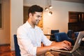 Smiling young formal dressed man working on laptop Royalty Free Stock Photo