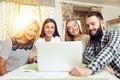 Smiling young friends using laptop in coffee shop Royalty Free Stock Photo