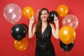 Smiling young girl in black dress celebrating wait for special moment, keeping fingers crossed, making wish on bright Royalty Free Stock Photo