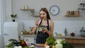 Smiling young girl eating fresh raw vegetable salad posing at kitchen having positive emotion Royalty Free Stock Photo