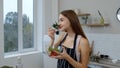 Smiling young girl eating fresh raw vegetable salad posing at kitchen having positive emotion Royalty Free Stock Photo