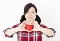 Smiling young girl holding a small red heart and her fingers in the form of heart. Royalty Free Stock Photo