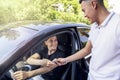 A smiling young girl receives the keys to a new car from the hands of a salesman car dealer car rental or purchase sale. bright Royalty Free Stock Photo