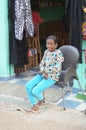 Smiling Young Girl Seated Outside Store in Egypt