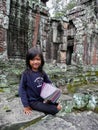 Smiling young girl is selling fabrics as souvenir, Angkor Wat, Cambodia