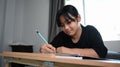 Young girl in sitting on her bed and doing homework. Royalty Free Stock Photo