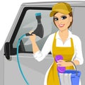 Smiling young girl with a soapy sponge and hose to wash a car Royalty Free Stock Photo