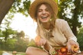 Smiling young girl in summer hat having a picnic at the park, Royalty Free Stock Photo