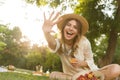 Smiling young girl in summer hat having a picnic at the park, Royalty Free Stock Photo