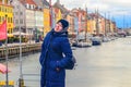 Young girl in warm winter clothes stands on the Nyhavn embankment. Copenhagen, Denmark Royalty Free Stock Photo