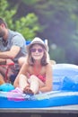 Portrait of smiling young girl wearing a hat and glasses while sitting in pool raft at pier Royalty Free Stock Photo