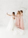 Smiling young girls taking a selfie together. Bride and bridesmaid making morning photo