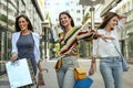 Smiling young girls walking on street with shopping bags. Royalty Free Stock Photo