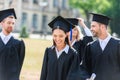 smiling young graduated students in capes