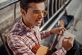 Smiling young guitarist writing in notebook outdoors Royalty Free Stock Photo