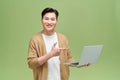 Smiling young handsome Asian man pointing hand to laptop computer Royalty Free Stock Photo