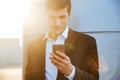 Smiling young handsome businessman using mobile phone outdoors Royalty Free Stock Photo