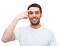 Smiling young handsome man pointing to forehead Royalty Free Stock Photo