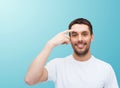 Smiling young handsome man pointing to forehead Royalty Free Stock Photo