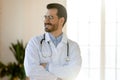 Smiling young handsome professional male doctor looking in distance. Royalty Free Stock Photo