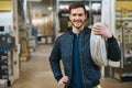 Smiling young handyman with a roll of cable Royalty Free Stock Photo