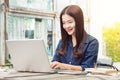 Smiling young happy asian woman using technology on her laptop c Royalty Free Stock Photo