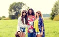 Smiling young hippie friends on green field