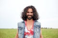 Smiling young hippie man on green field