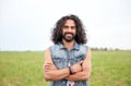 Smiling young hippie man on green field