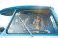 Smiling young hippie woman driving minivan car Royalty Free Stock Photo