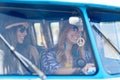 Smiling young hippie women driving minivan car Royalty Free Stock Photo