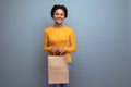 smiling young hispanic woman with black curly hair holding craft bag Royalty Free Stock Photo