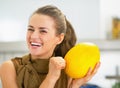 Smiling young housewife checking ripeness of melon Royalty Free Stock Photo