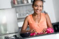 Smiling young housewife making fruit salad Royalty Free Stock Photo