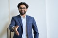 Smiling young indian business man wearing suit extending hand for handshake. Royalty Free Stock Photo