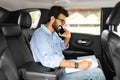 Smiling young indian businessman talking over phone, sitting in taxi Royalty Free Stock Photo