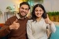 Smiling young Indian family couple man woman sitting showing thumbs up giving approval good feedback Royalty Free Stock Photo