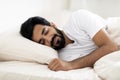 Smiling Young Indian Man Sleeping Calmly In Comfortable Bed At Home Royalty Free Stock Photo