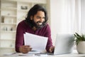 Smiling Young Indian Man Working With Papers And Laptop At Home Office Royalty Free Stock Photo